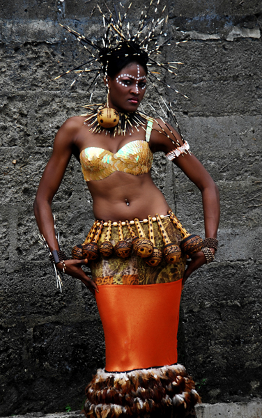 Bayo Adegbe Bra top embellished with sequins, lycra skirt, feathers, gourds, hair arrangement of porcupine quills.