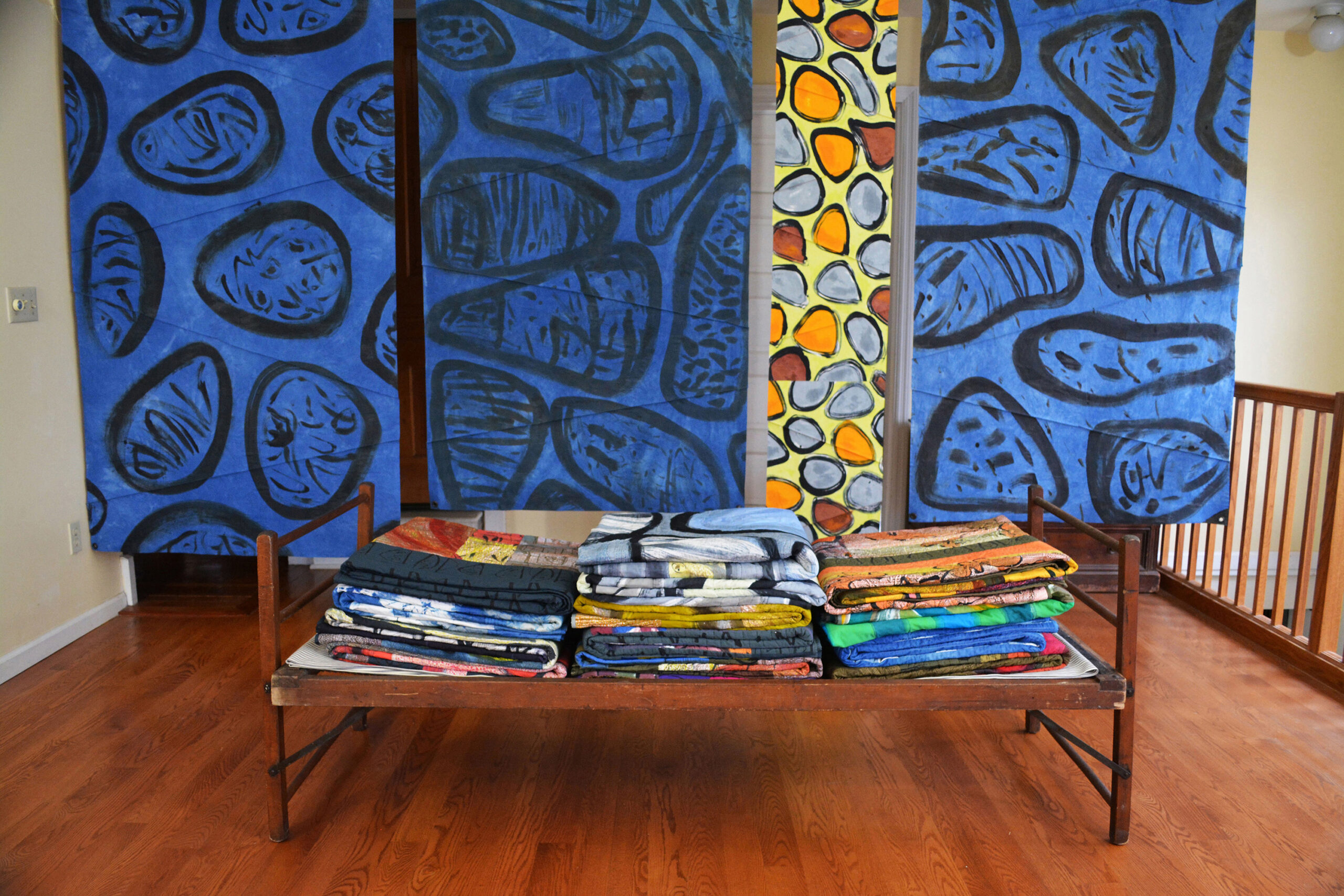 Installation with Indigo: Stacked quilts on vintage cot